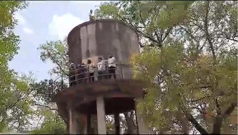पानी टंकी पर चढ़कर व्यापारियों का हंगामाः एसडीएम के आश्वासन पर उतरे नीचे, दुकानों की नीलामी स्थगित