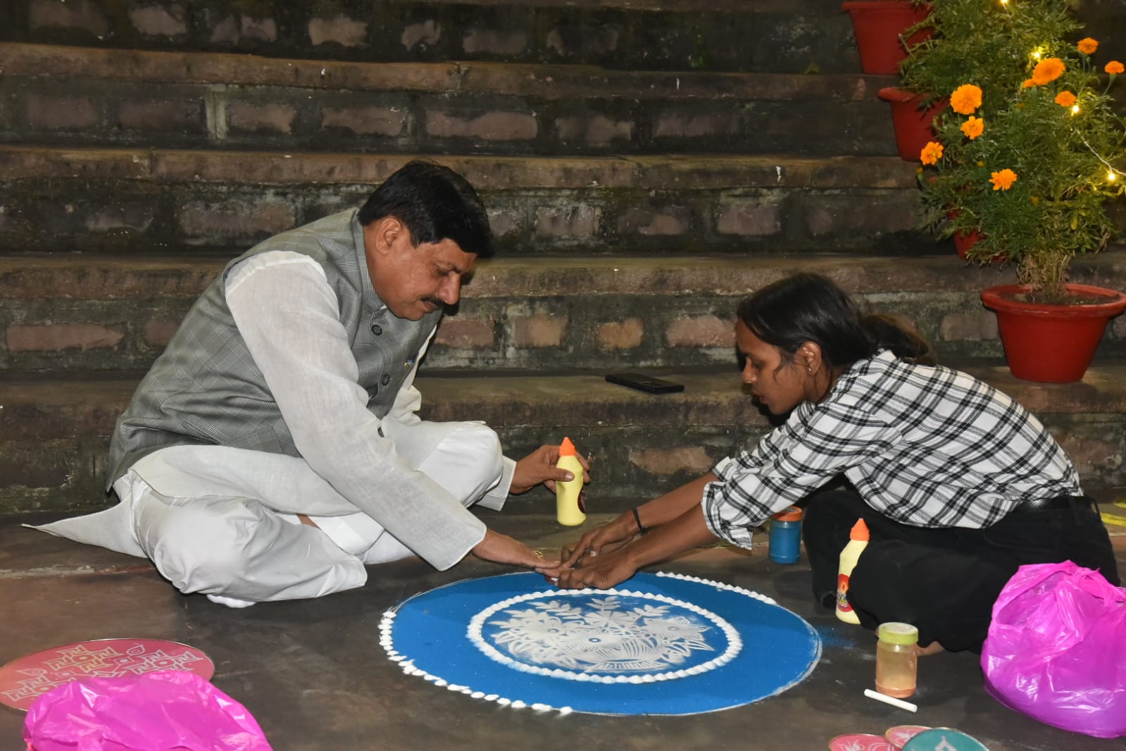 CM डॉ मोहन ने मुख्यमंत्री निवास में बनाई रंगोली, बच्ची के साथ जमीन पर बैठकर पारंपरिक कला में आजमाए हाथ