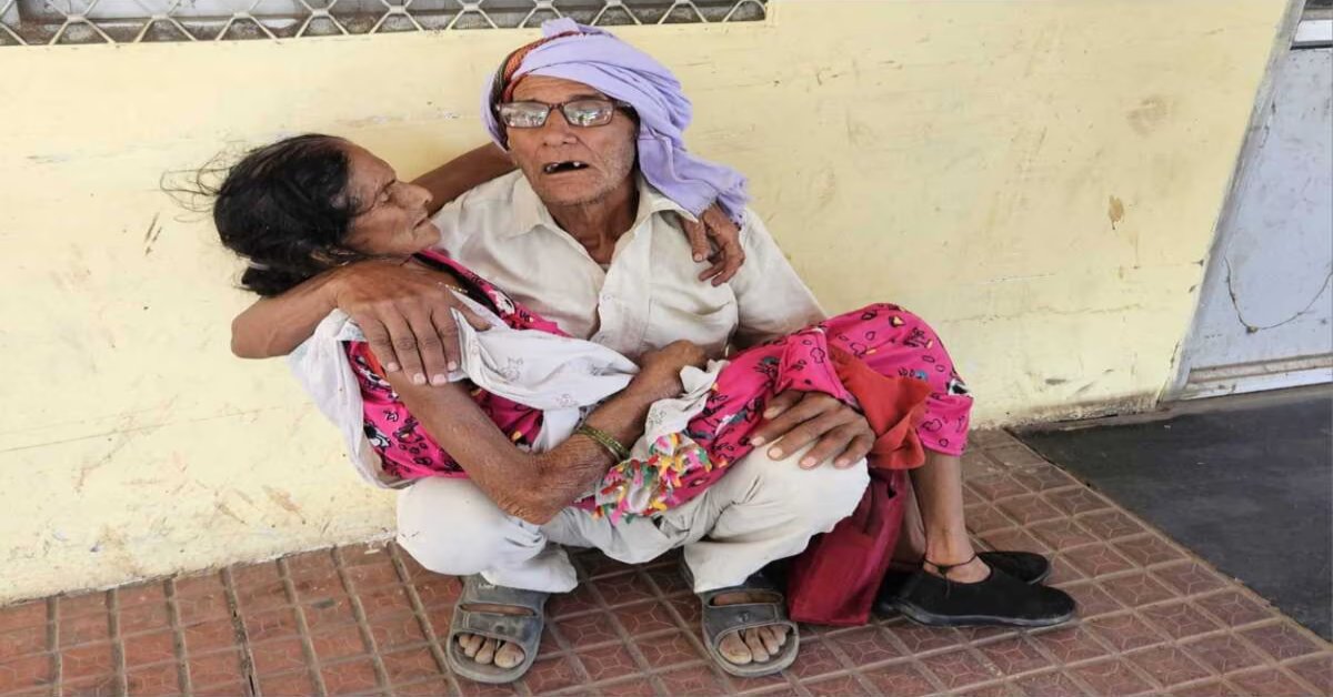 UP में स्वास्थ्य सेवाएं बदहाल, बुजुर्ग महिला को नहीं मिला एंबुलेंस और स्ट्रेचर तो गोद में लेकर बैठ गया पति, VIDEO वायरल