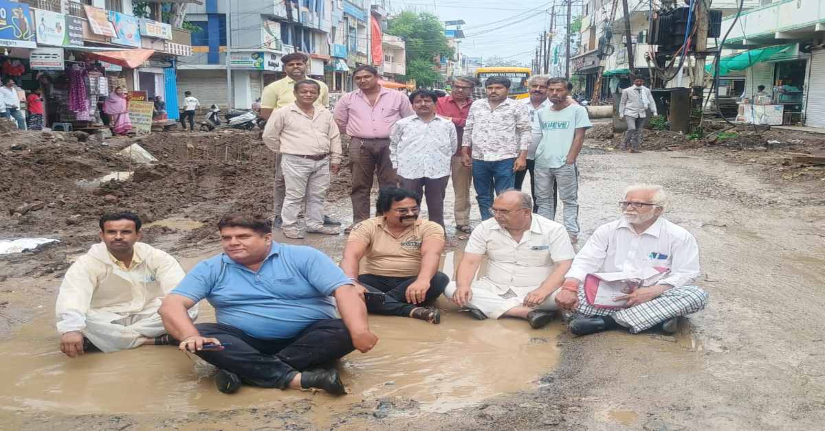 सड़क निर्माण में लेट लतीफी: लोगों का फूटा गुस्सा, कीचड़ भरे गड्ढों में बैठकर दिया धरना…